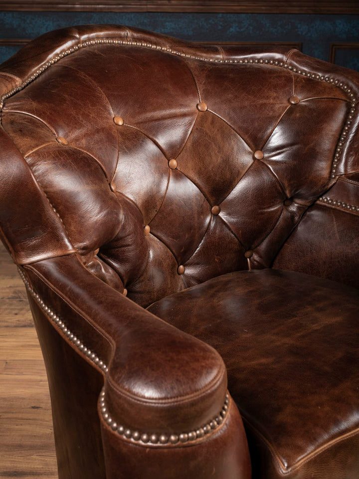 Close-up of diamond tufting and soft wax-finished Dark Rum buffalo leather on the swivel chair inback
