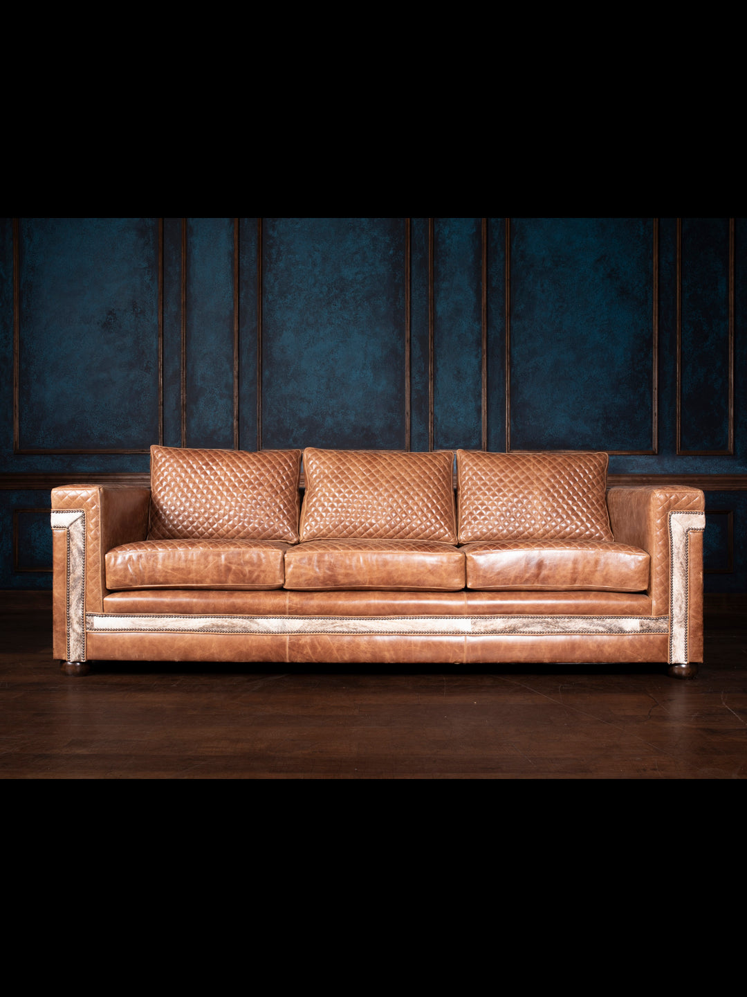 Desert Luxe Leather Architect Sofa in a room, showcasing premium quilted leather and unique hair-on-hide accents, exemplifying handcrafted American quality and Western elegance.