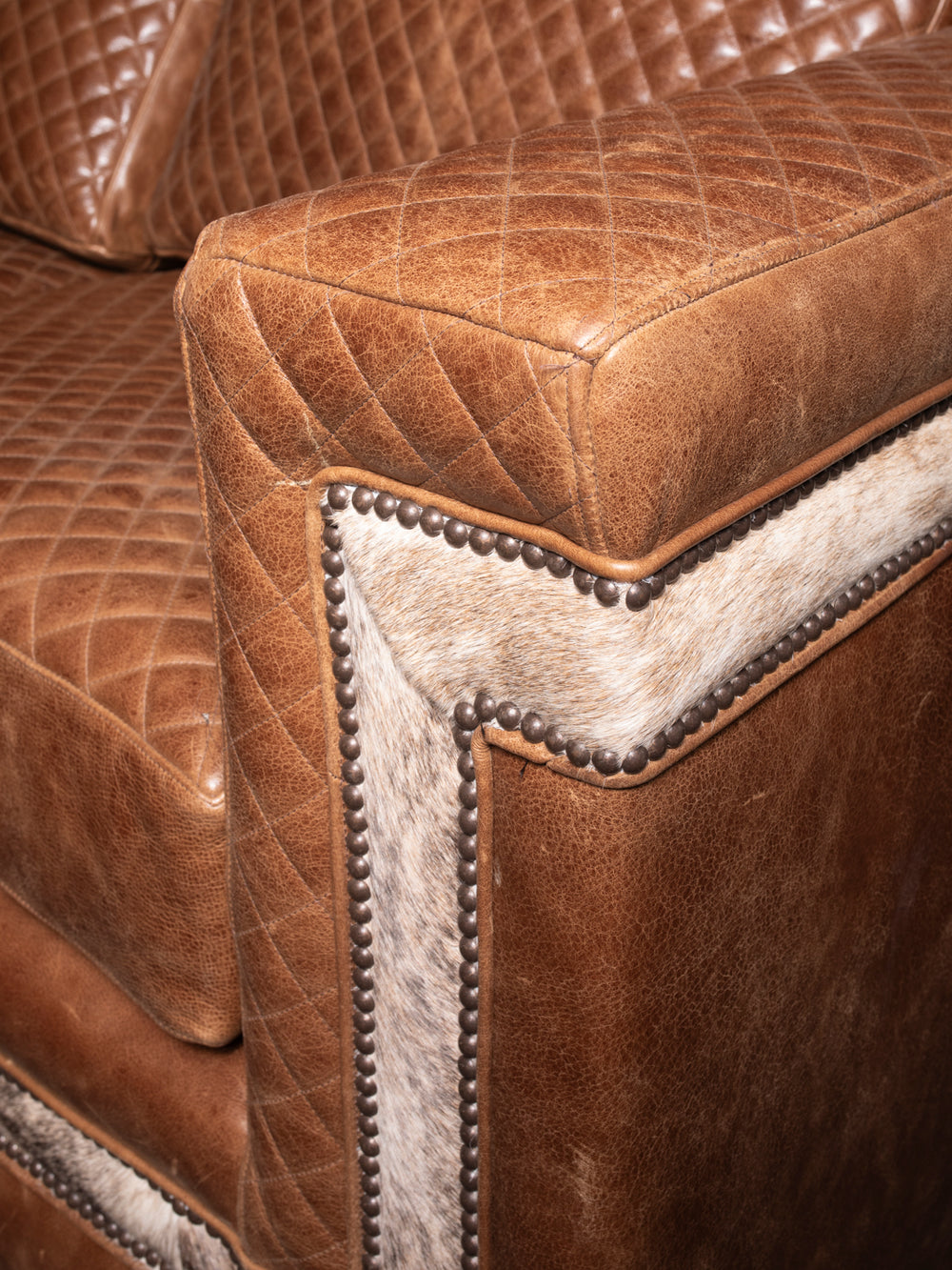 Close-up of the Desert Luxe Leather Architect Sofa, showcasing its premium quilted leather and unique hair-on-hide accents, ideal for rustic and luxury interiors.