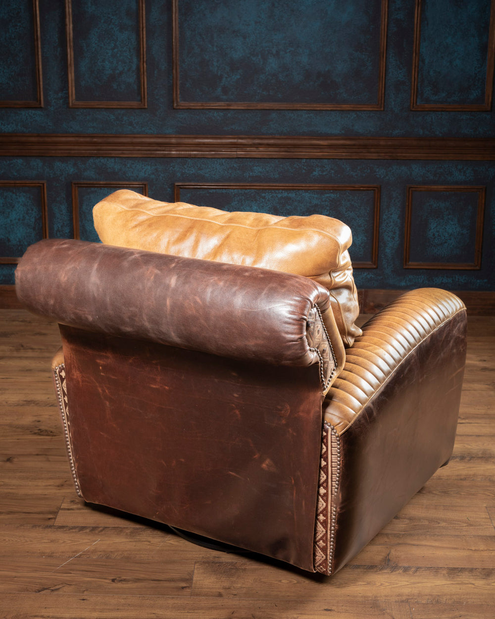 Full backside view of the Dutton Western swivel recliner highlighting the deep chocolate pull-up leather wrap and rolled headrest frame.