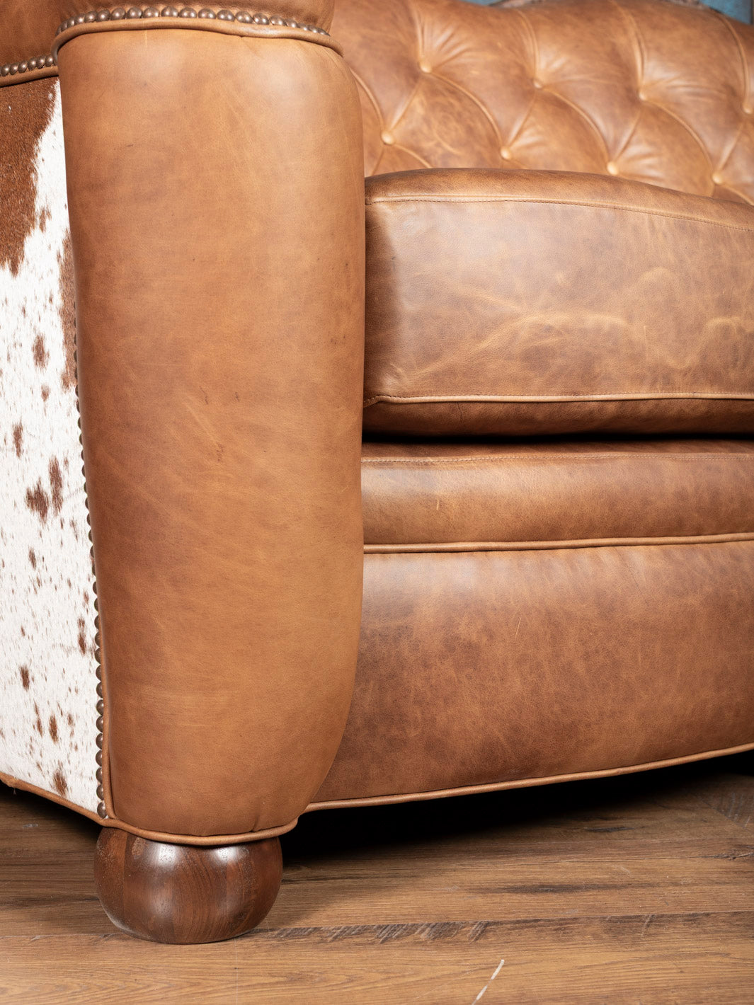 Golden Range Leather Sofa in a chestnut brown leather and western detailing in a close up view.