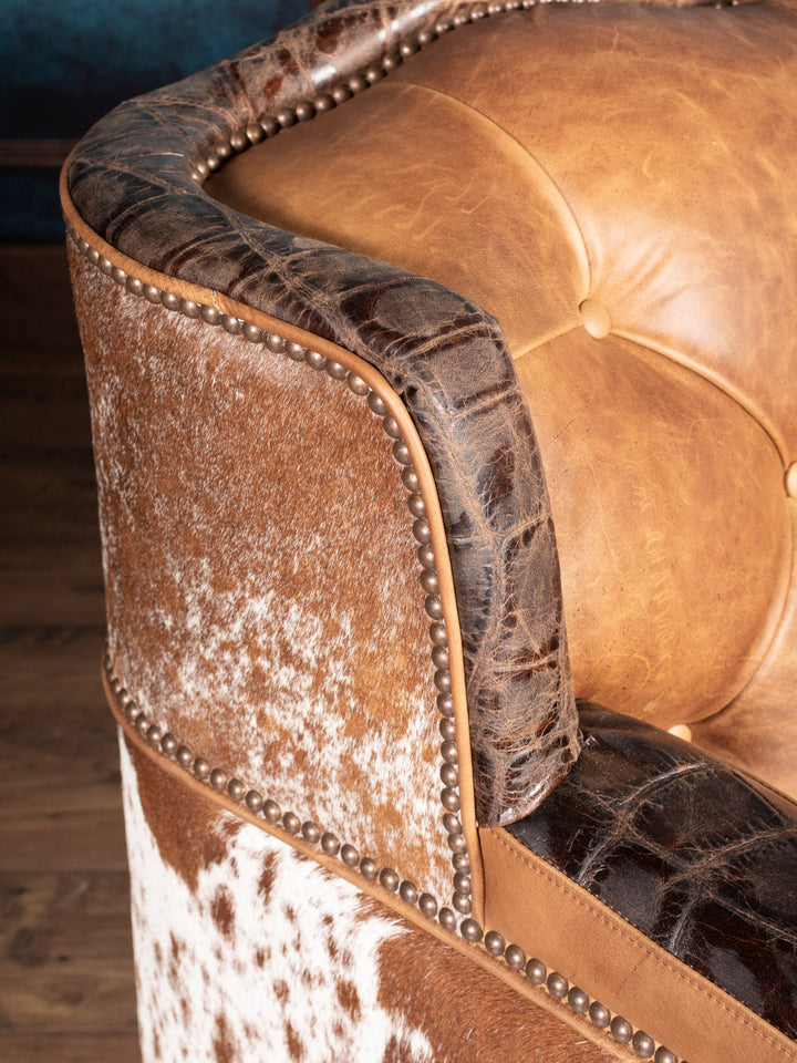 Golden Range Leather Sofa with a embossed crocodile trim and brass nailhead detailing in a close up view. 