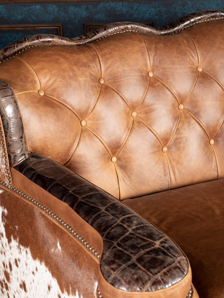 Golden Range Leather Sofa in a chestnut brown leather with deep tufted inside back detailing and crocodile accents in a close up view. 
