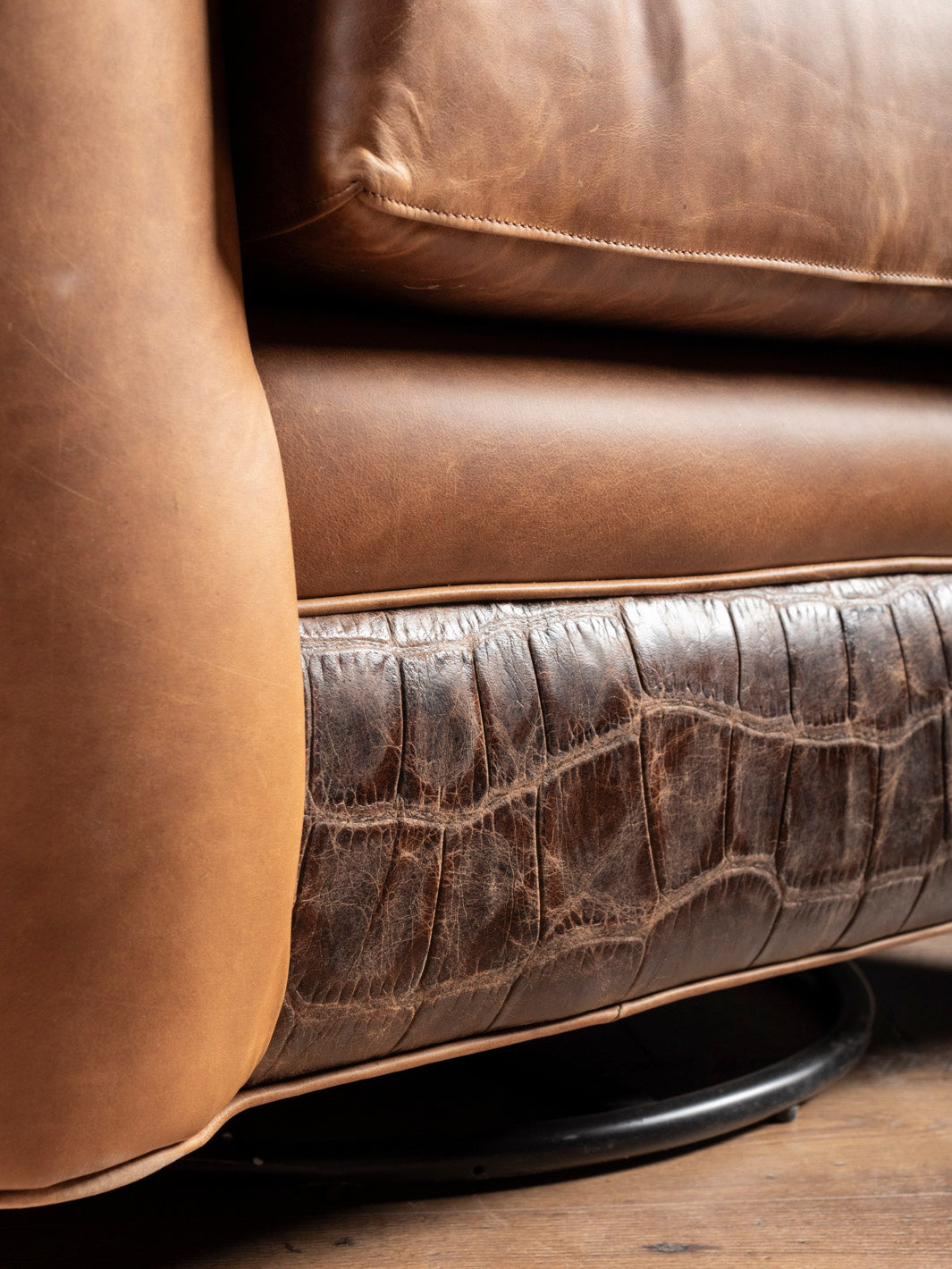 Golden Range Swivel Chair in a chestnut leather paired with embossed crocodile leather accent in a close up view.