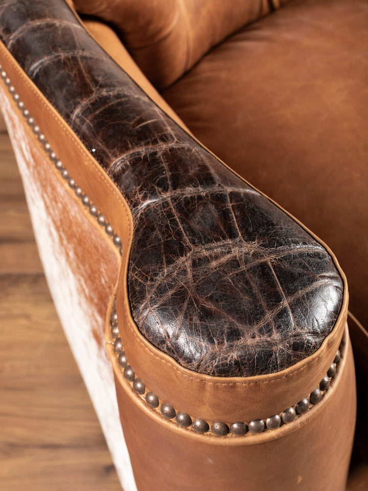 Golden Range Swivel Chair featuring brown crocodile embossed leather trim on arm in a close-up view.