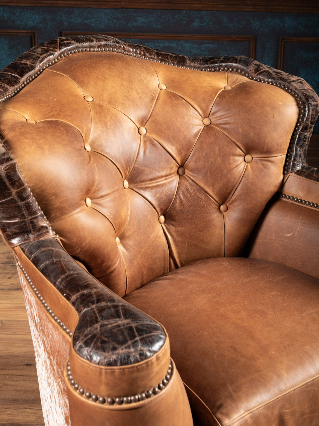 Golden Range Swivel Chair in brown leather with tufted inside back detailing in a close-up space.