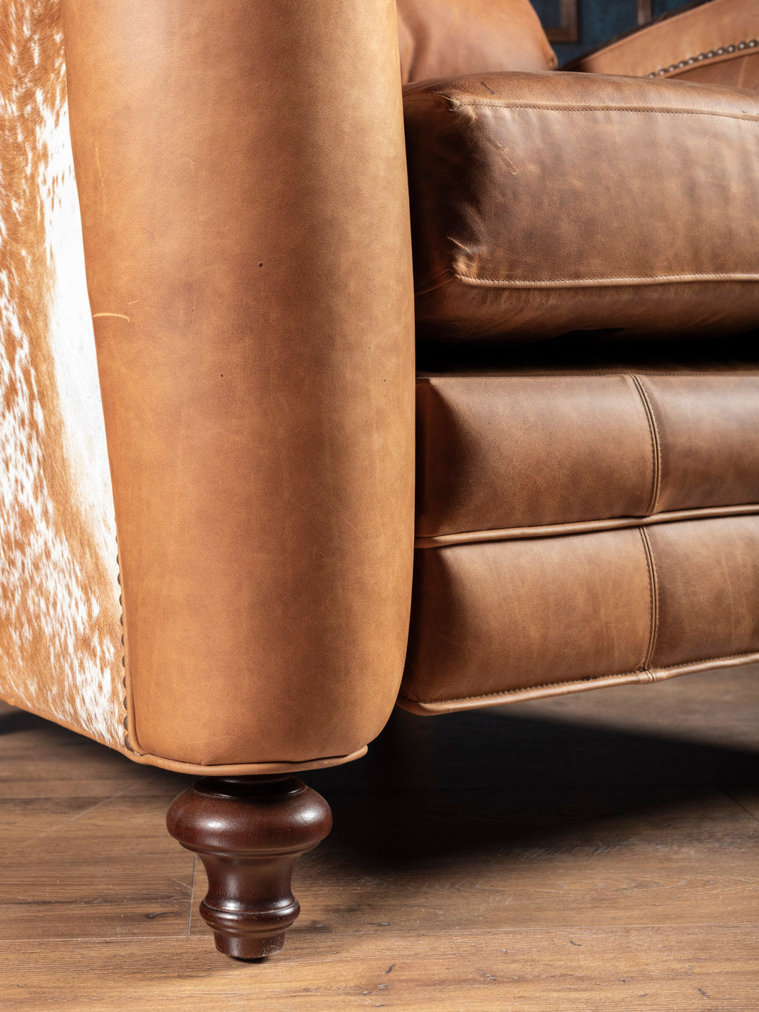 Golden Range Handcrafted Western Recliner with walnut bun foot detail and full-grain leather in a close up view. 
