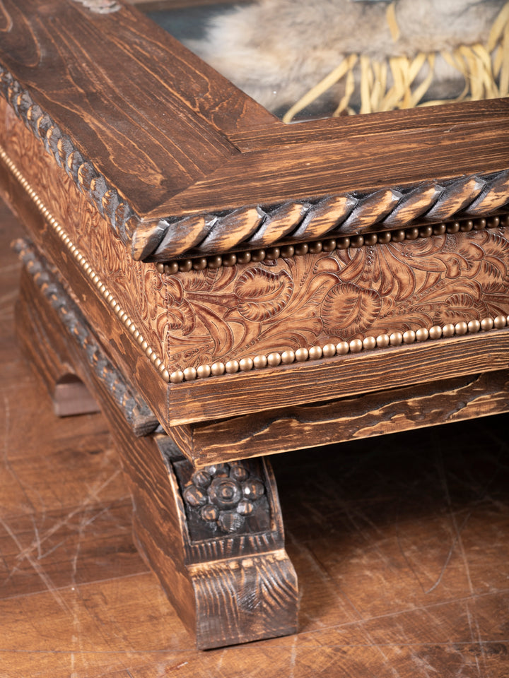 Saddle Ridge Coffee Table with hand carved wood and floral embossed leather in a close-up view.