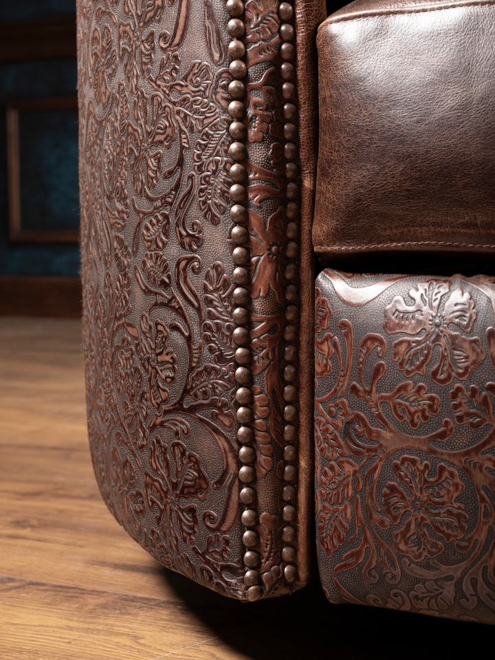 Hideout Leather Snug Swivel Recliner with tooled floral leather panels and nailhead trim, shown in a close-up view.