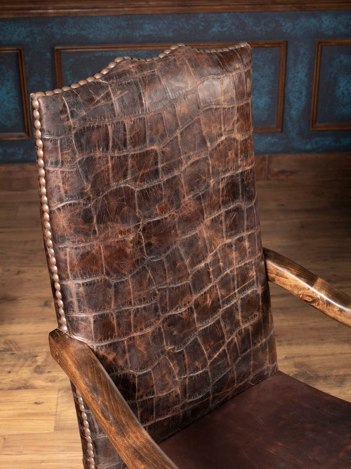 Close up view of the jumbo crocodile embossed leather high back with hand-driven nailhead trim on a Western executive chair.