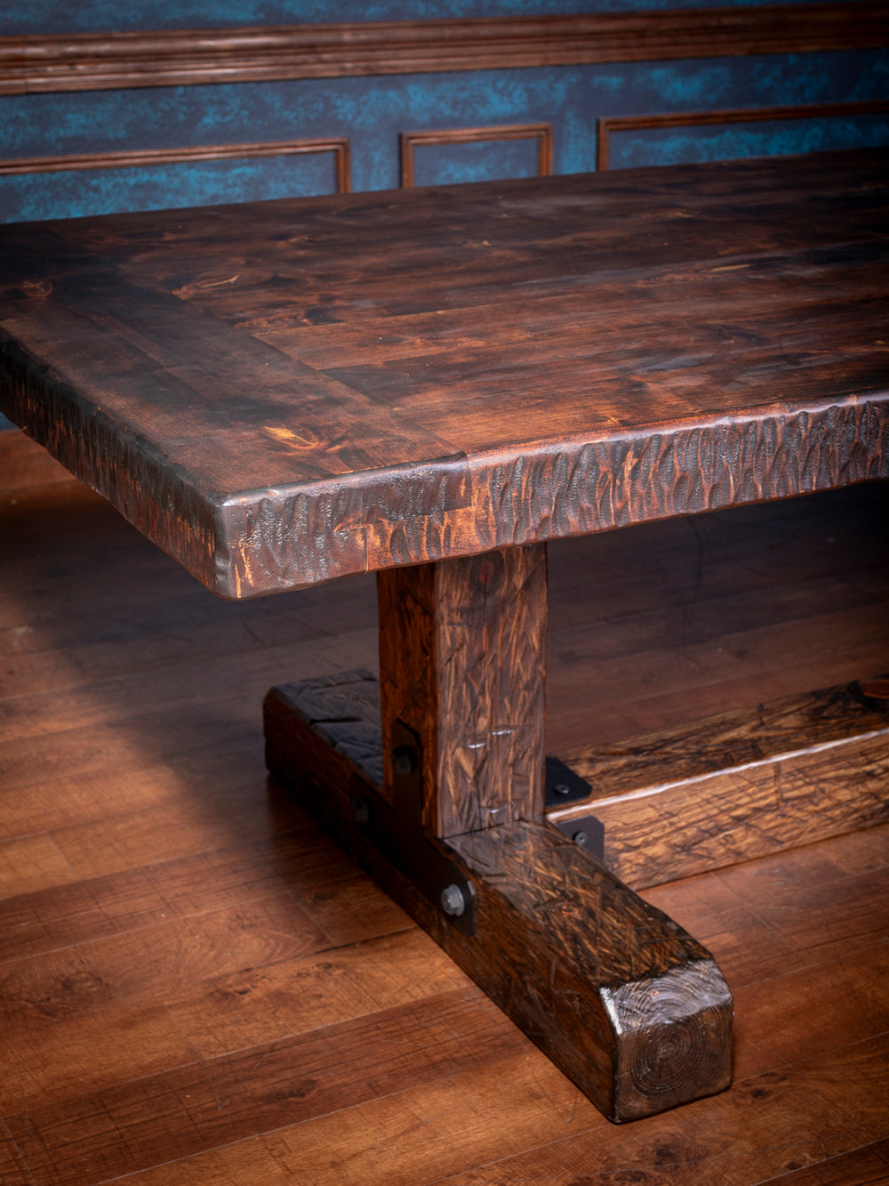 Knotty Alder Rustic Dining Table in solid knotty alder wood with dark rustic stain, and a hand-hewn edge in a close-up view.
