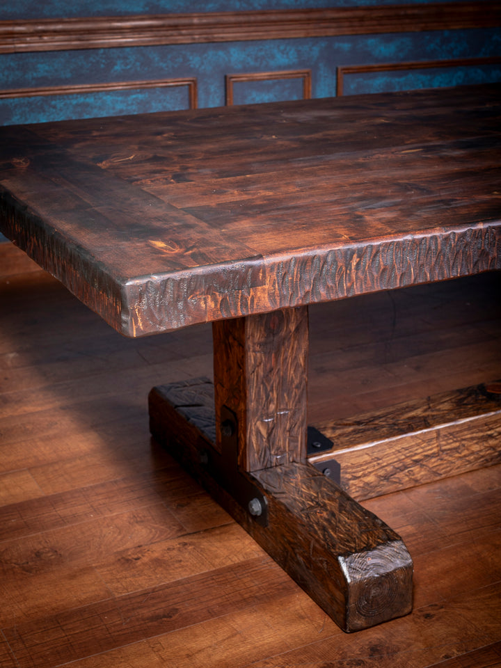 Knotty Alder Rustic Dining Table in solid knotty alder wood with dark rustic stain, and a hand-hewn edge in a close-up view.