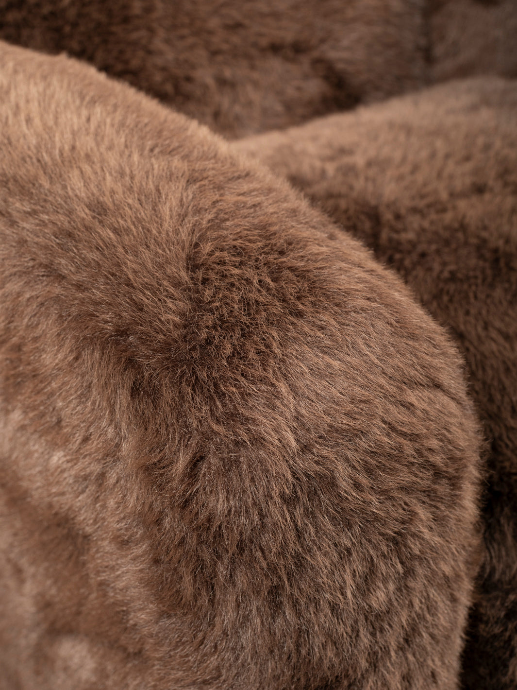 Brown faux fur upholstery detail on the Kodiak Grizzly-Brown Swivel Chair, showing the plush texture along the arm.