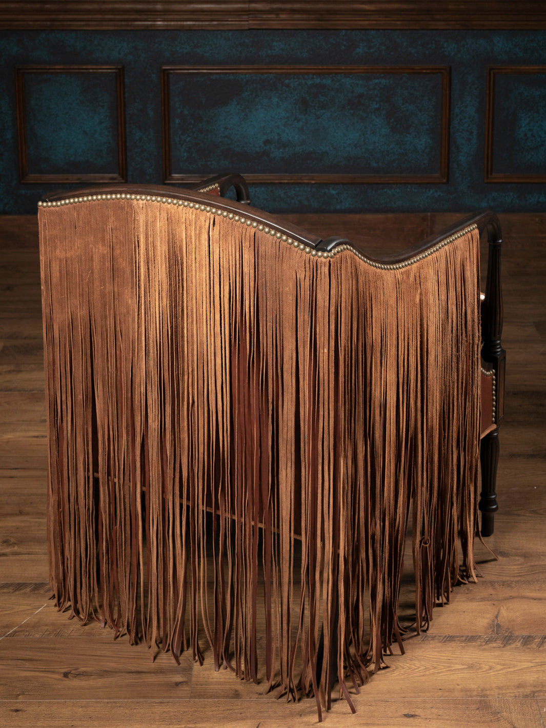 Full rear view of the Boulder Western leather accent chair completely enveloped in a dramatic, heavy curtain cape of long hand-cut brown suede fringe.