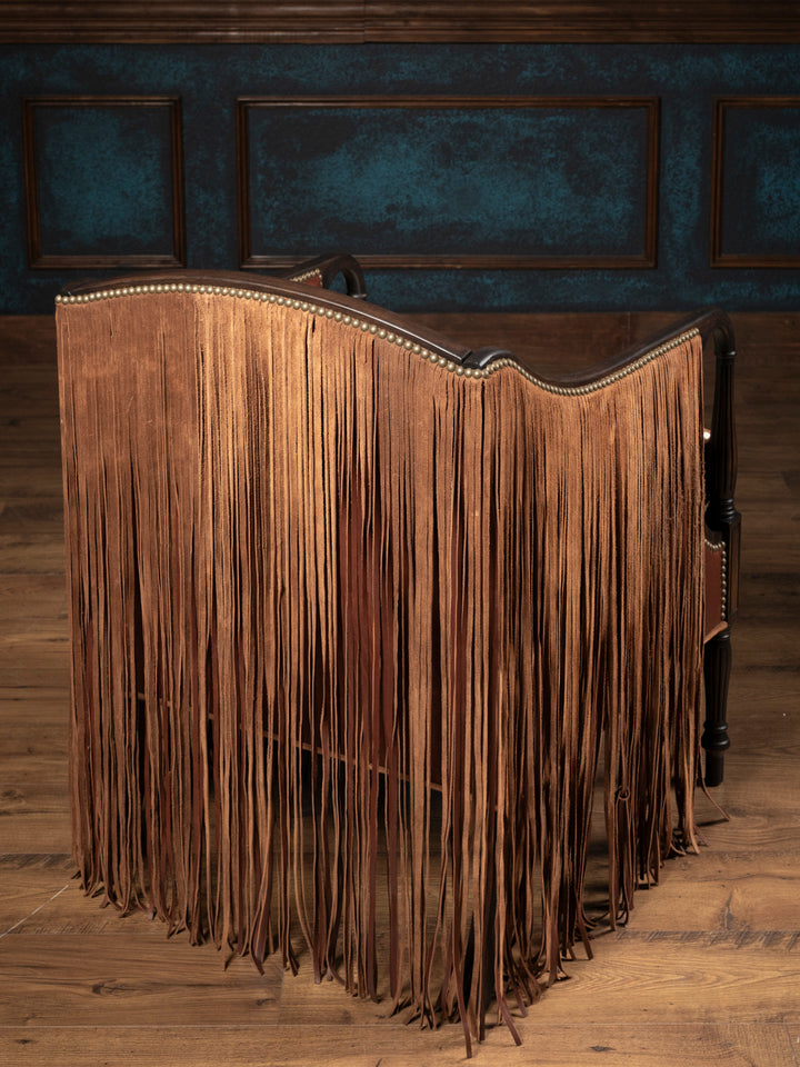 Full rear view of the Boulder Western leather accent chair completely enveloped in a dramatic, heavy curtain cape of long hand-cut brown suede fringe.