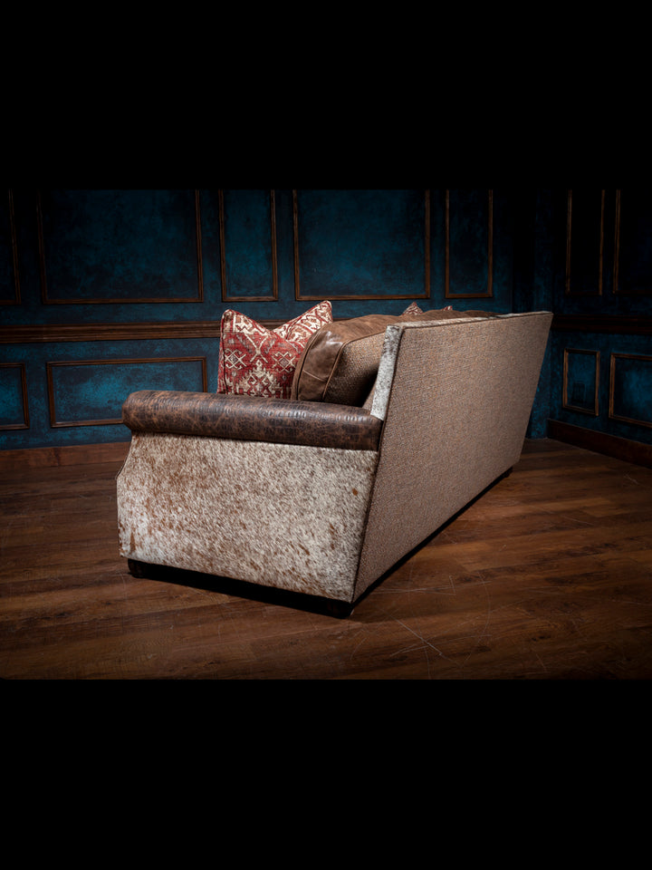 Luxurious Leather and Fabric Sofa with cowhide panels and fabric outside back in moody western space.
