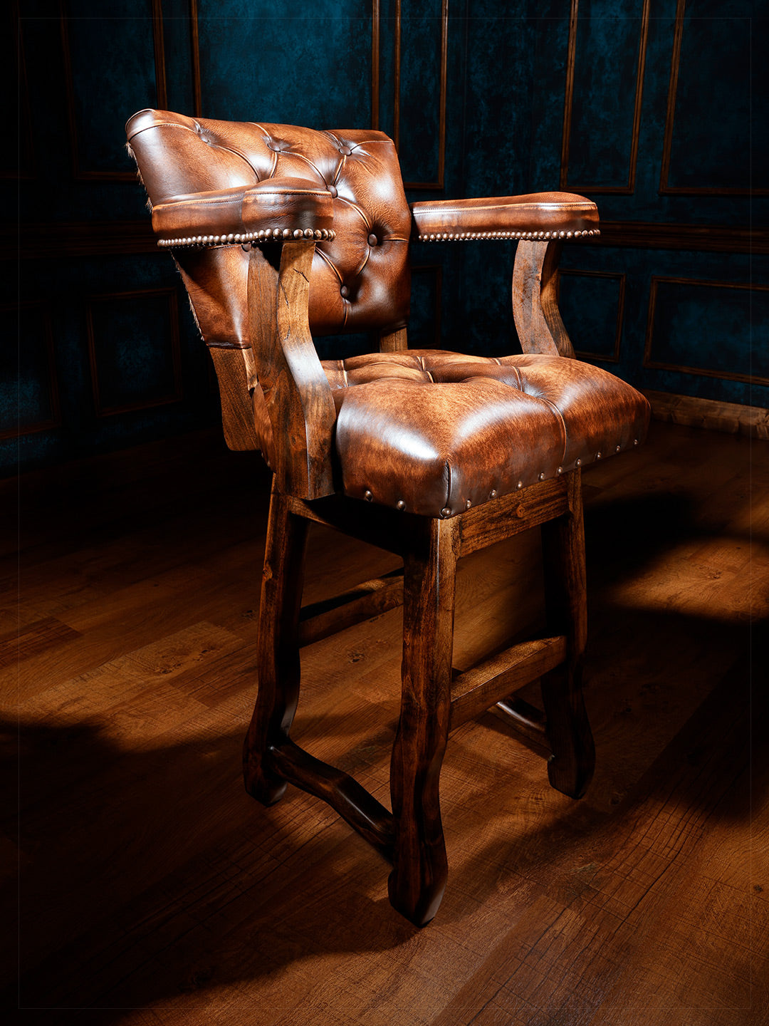 Lodge Axis Western Bar Stool in full grain brown leather with tufted seats in a moody western bar space.
