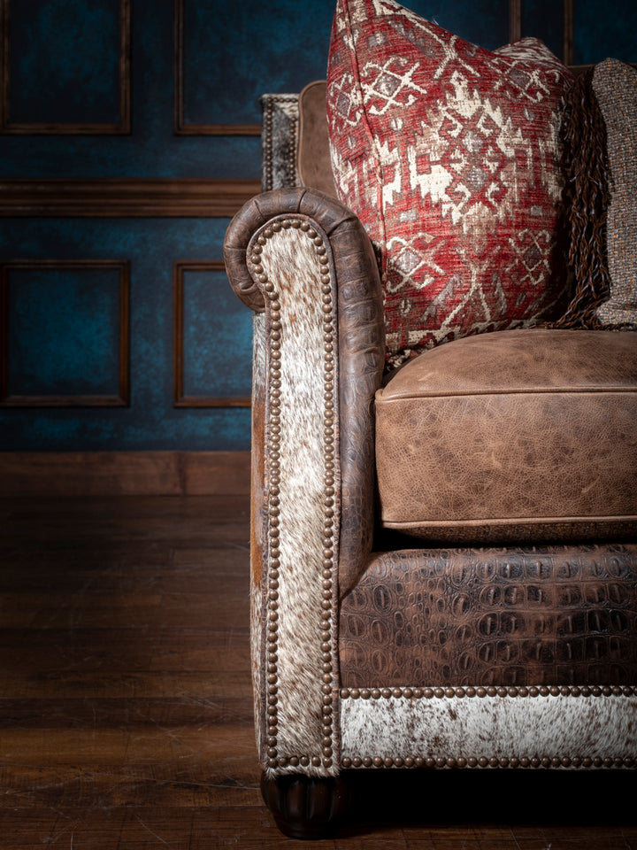Luxurious Leather and Fabric Sofa with brown leather seats and crocodile trim accents in a close up view. 