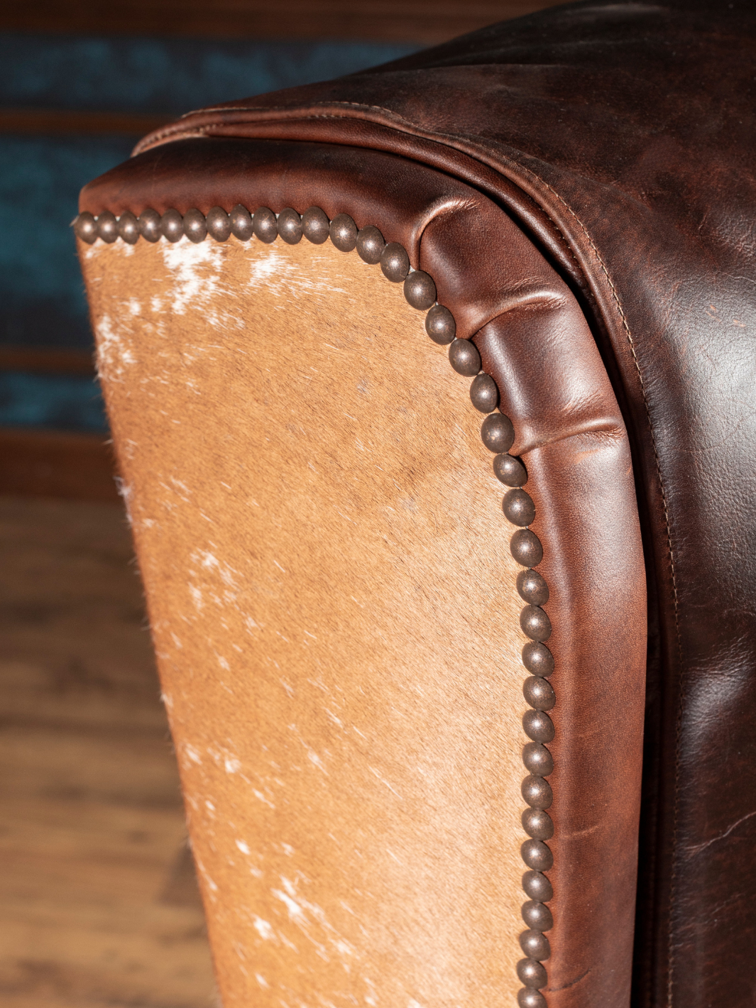 Midland Leather Desk Chair with brown leather and cowhide accents framed by nailhead trim, in a close-up view. 