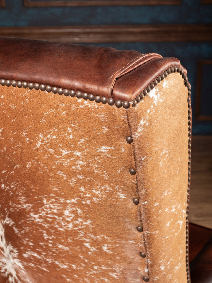 Midland Executive Leather Desk Chair with speckled cowhide side panel and antique nailhead trim, shown in a close-up view.