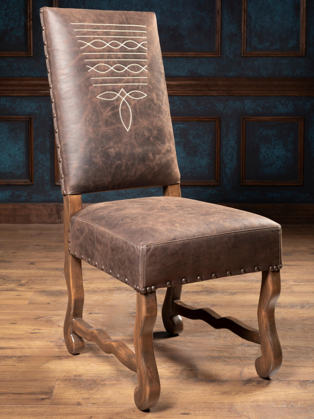 Mustang Leather Dining Chair with distressed brown leather and boot stitch detailing in a rustic dining space. 