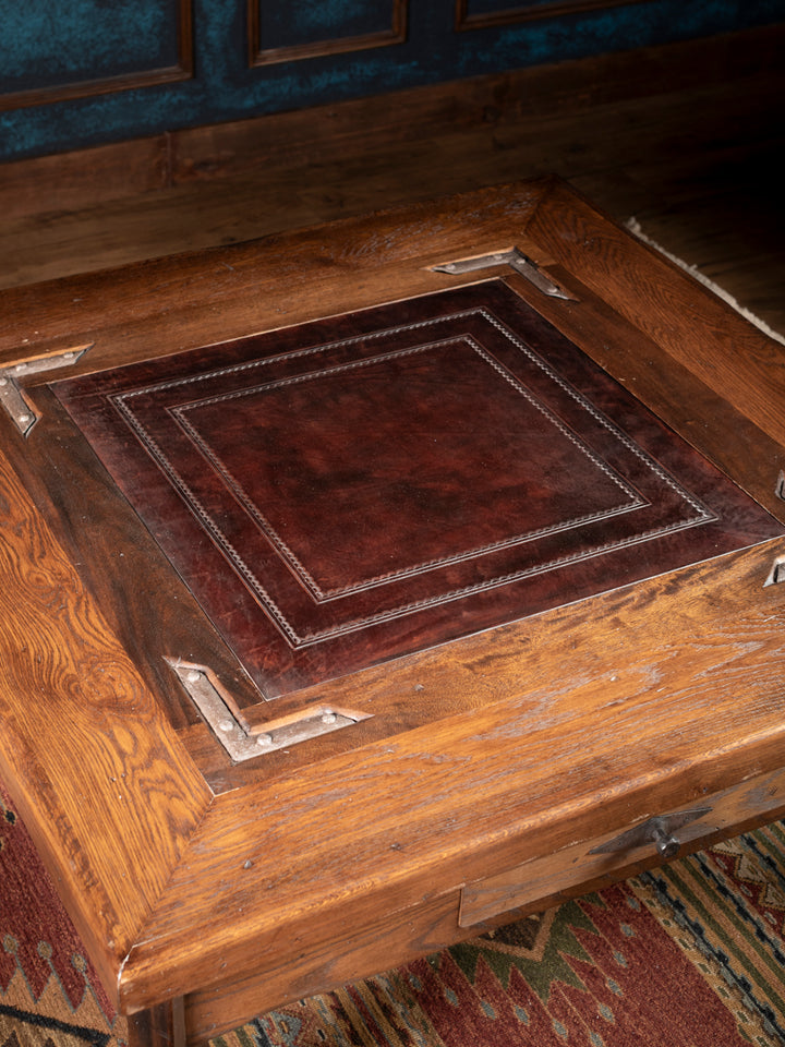 Nevada Cocktail Table with brown leather inlay and distressed brown wood surface in a close-up view.