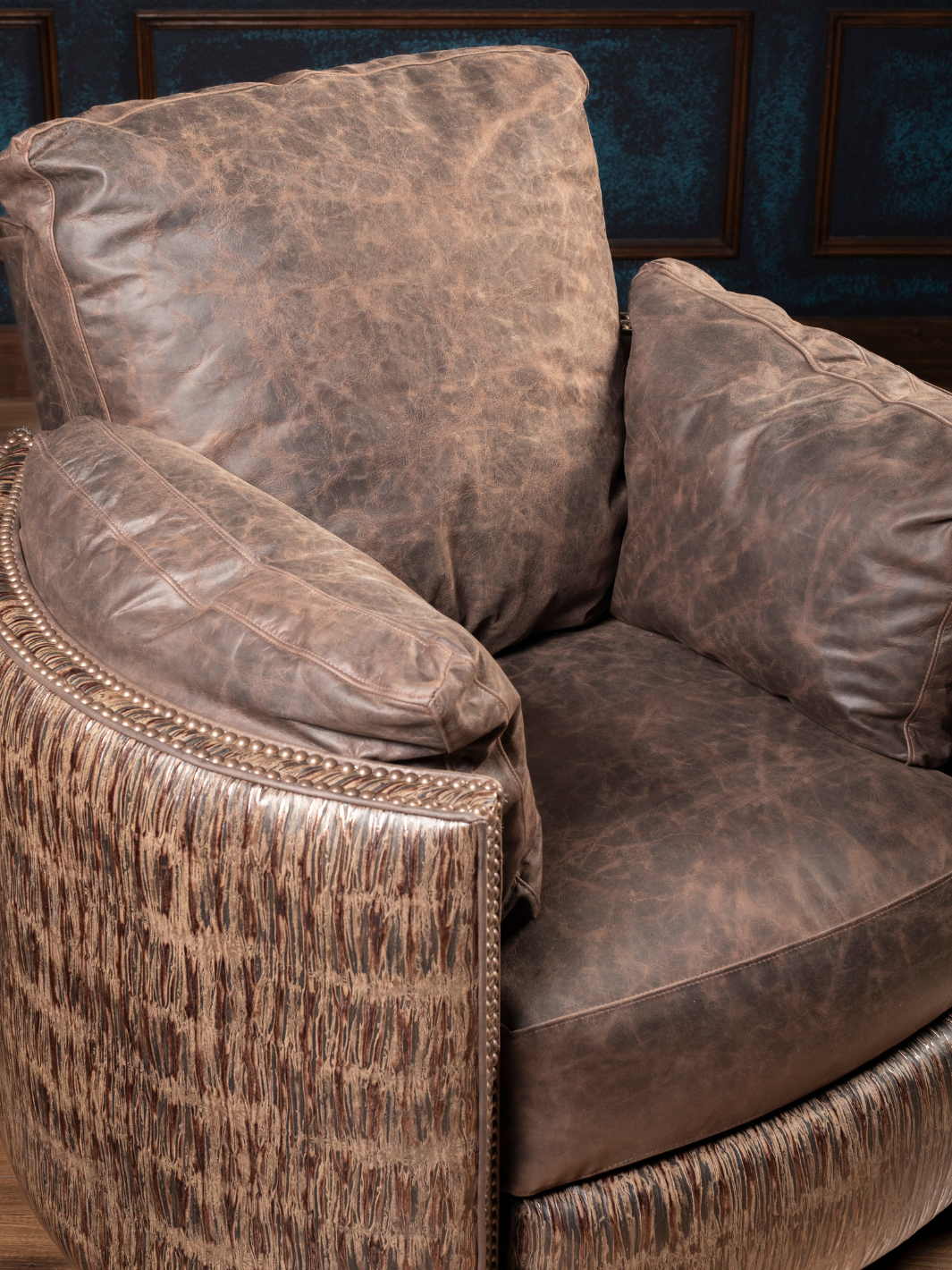 Rimrock Leather Snug Swivel Recliner with distressed leather cushions and embossed leather accents, in a close-up view.