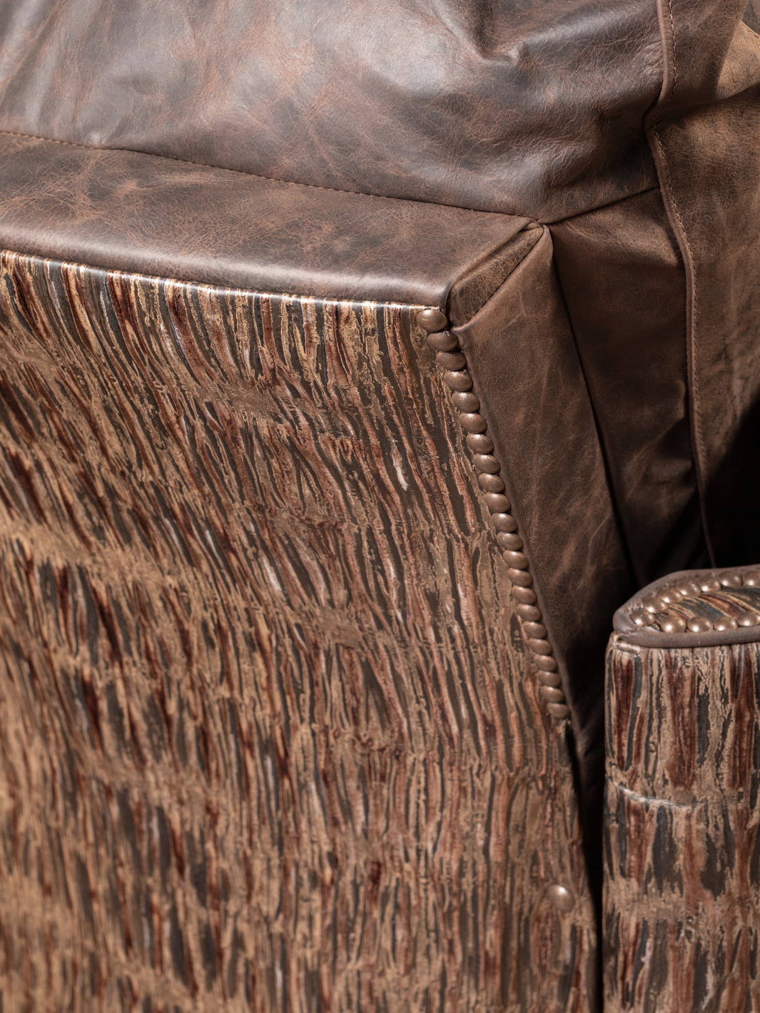 Rimrock Leather Snug Swivel Recliner with embossed leather side panel and nailhead trim, shown in a close-up view.