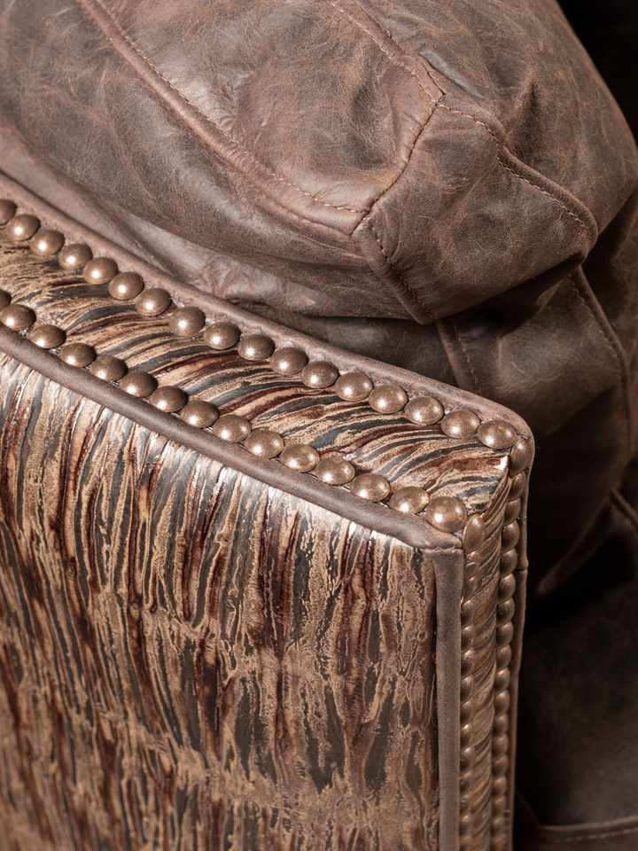 Rimrock Leather Snug Swivel Recliner with embossed leather arm panel and nailhead trim, shown in a close-up view.