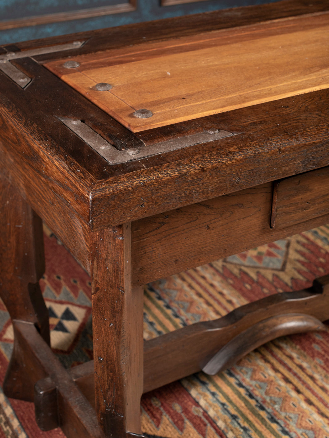 Close-up of a wooden console with a textured surface and visible hardware.