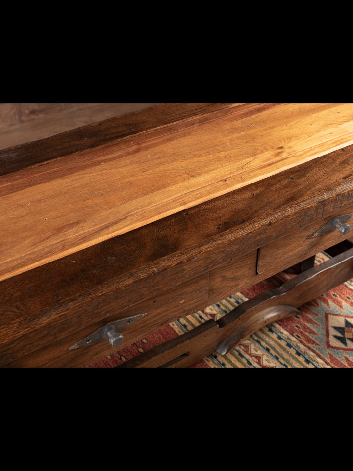 Close-up of a wooden console with a textured surface and visible grain.