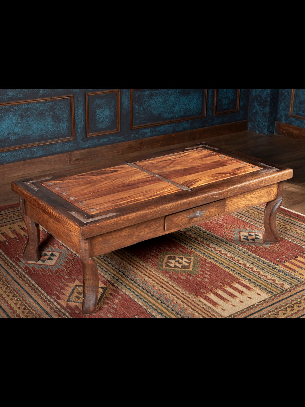 Wooden coffee table in a room with patterned rug and blue walls
