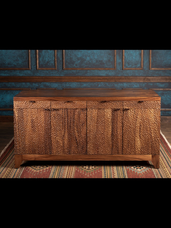 Wooden sideboard against a decorative wall with blue wallpaper