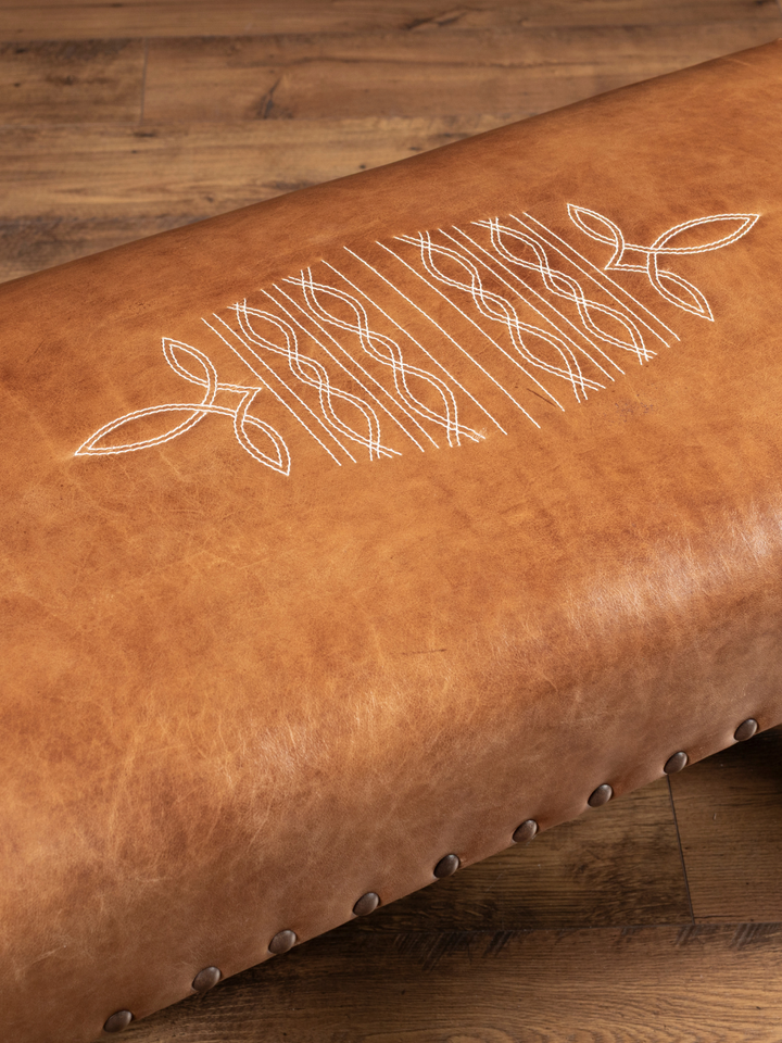Close-up of signature cowboy boot stitch embroidery on the saddle brown leather Santa Fe Bench.