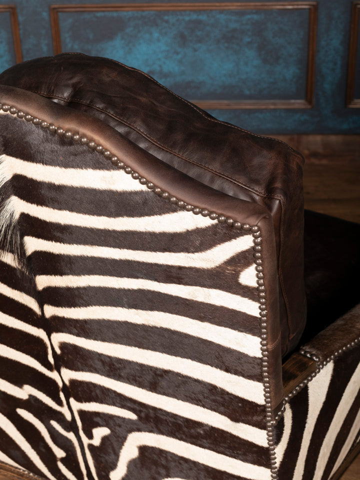 Safari Reserve Zebra Leather Chair with zebra accents and brass nailhead trim shown in a close-up view.