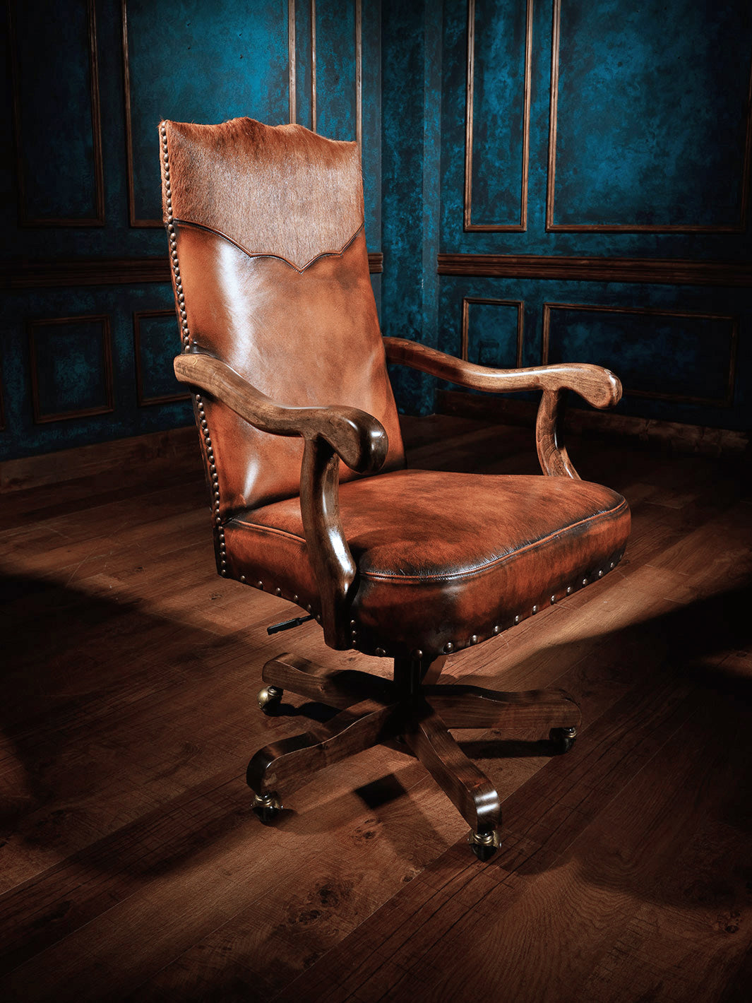 Sanderson Western Leather Desk Chair in burnished brown full grain leather and with sculpted alder wood arm rest in a rustic space.