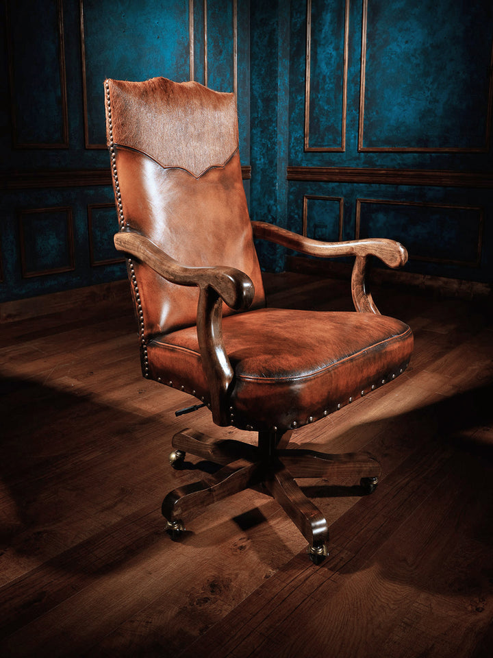 Sanderson Western Leather Desk Chair in burnished brown full grain leather and with sculpted alder wood arm rest in a rustic space.