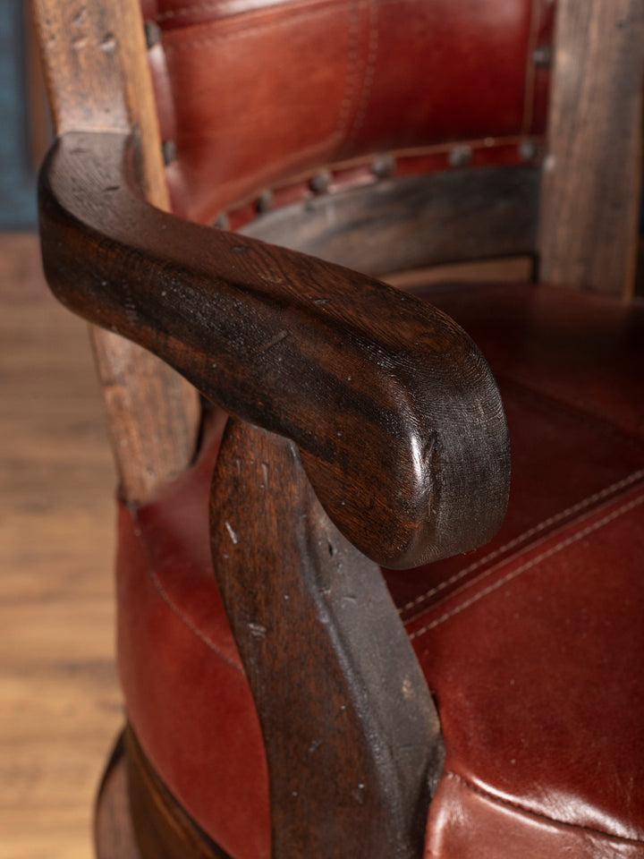 Close-up of a wooden armrest on a leather bar stool with a blurred background