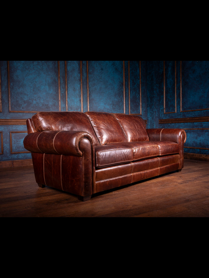 Sierra Leather Sofa in brown Chestnut leather with oversized rolled arms and brown block feet in a rustic living room.