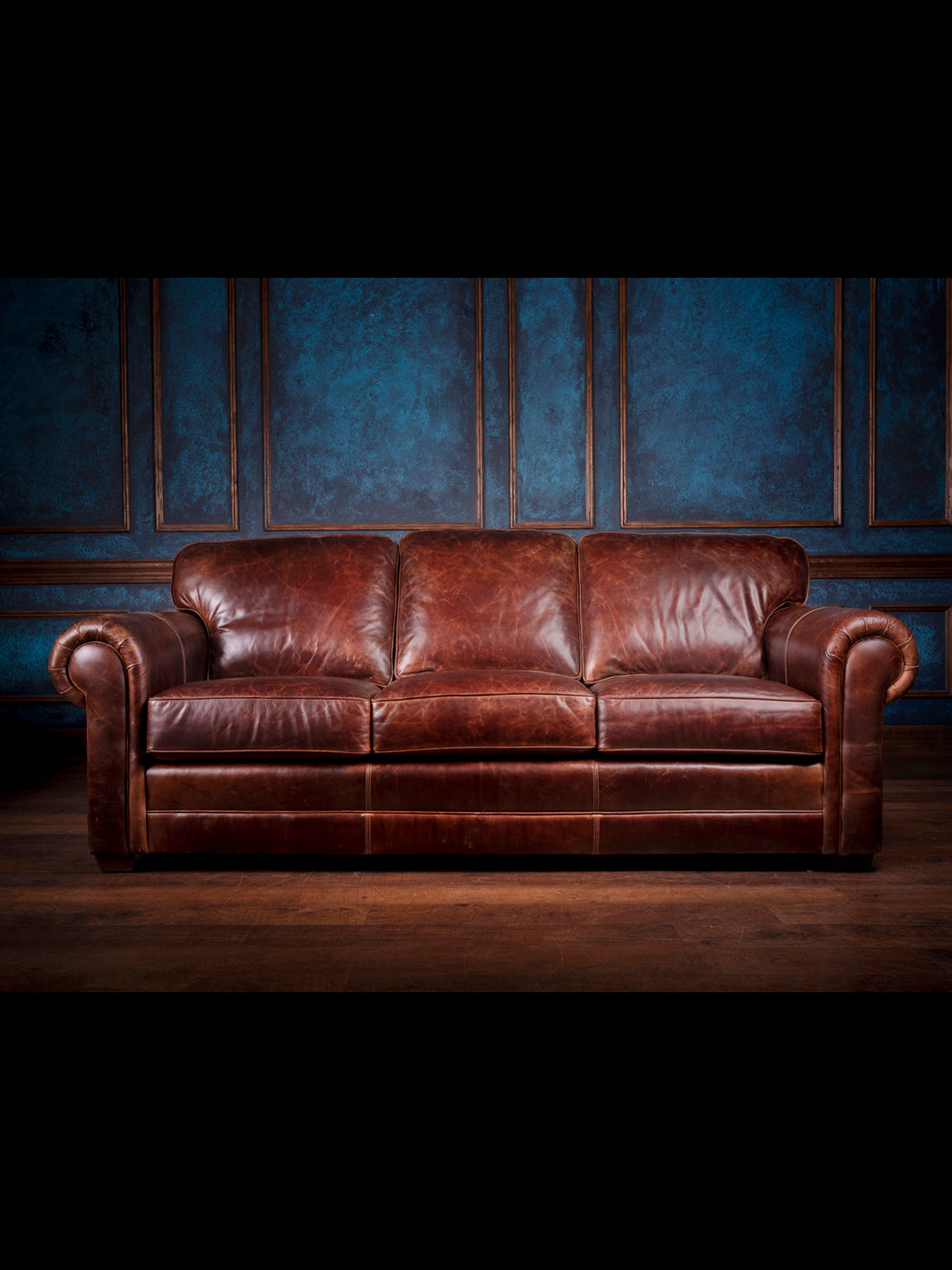Sierra Leather Sofa in full-grain Chestnut brown leather with oversized rolled arms in a western style room. 