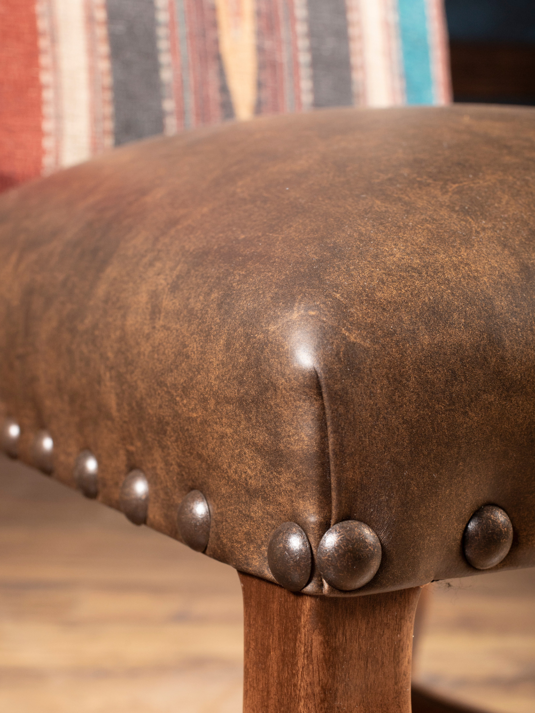 Southwestern Stripe Leather Dining Chair seat in a two-tone brown burnished leather in a close-up view.