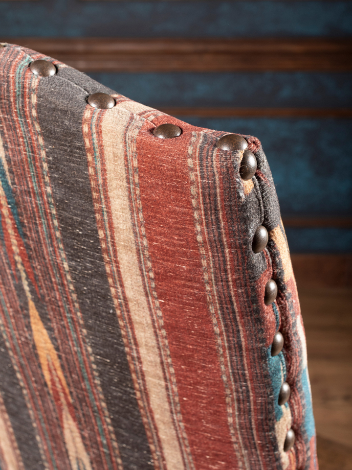 Southwestern Stripe Leather Dining Chair with stripe fabric accented by brass nailhead trim in a close-up view.