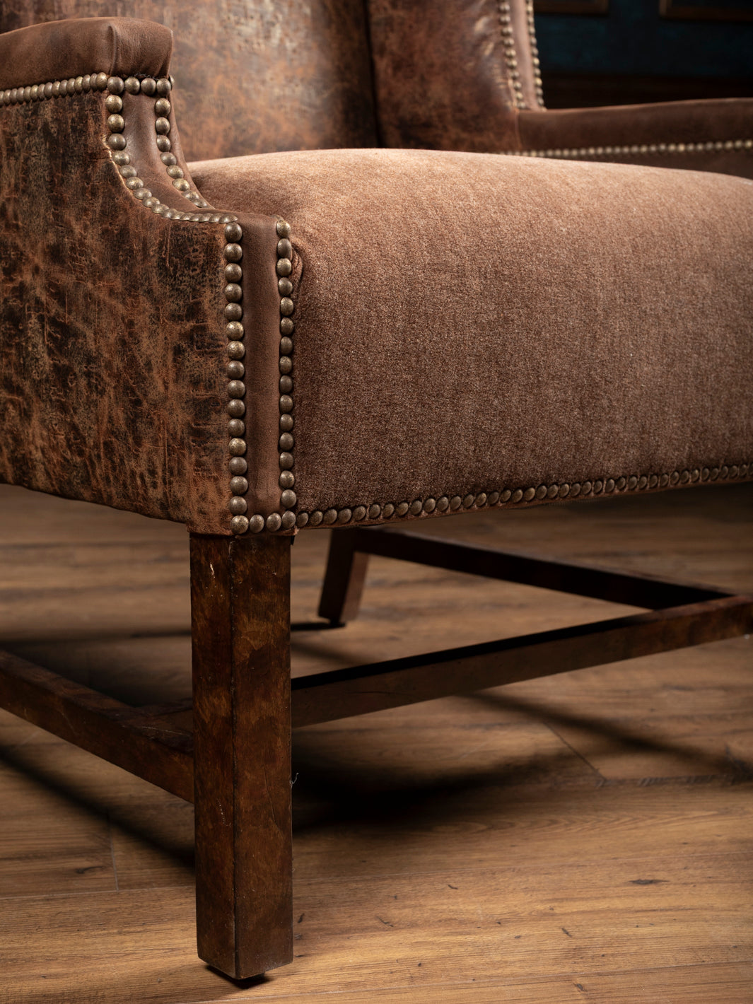 Close up of Stockman Accent Chair with velvet seat and western embossed leather panels.