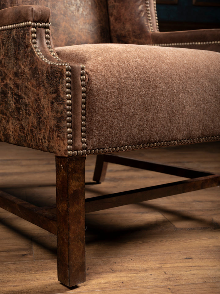 Close up of Stockman Accent Chair with velvet seat and western embossed leather panels.