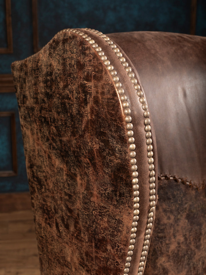 Close-up of distressed embossed leather and double rows of nailhead trim on the Stockman chair’s wing