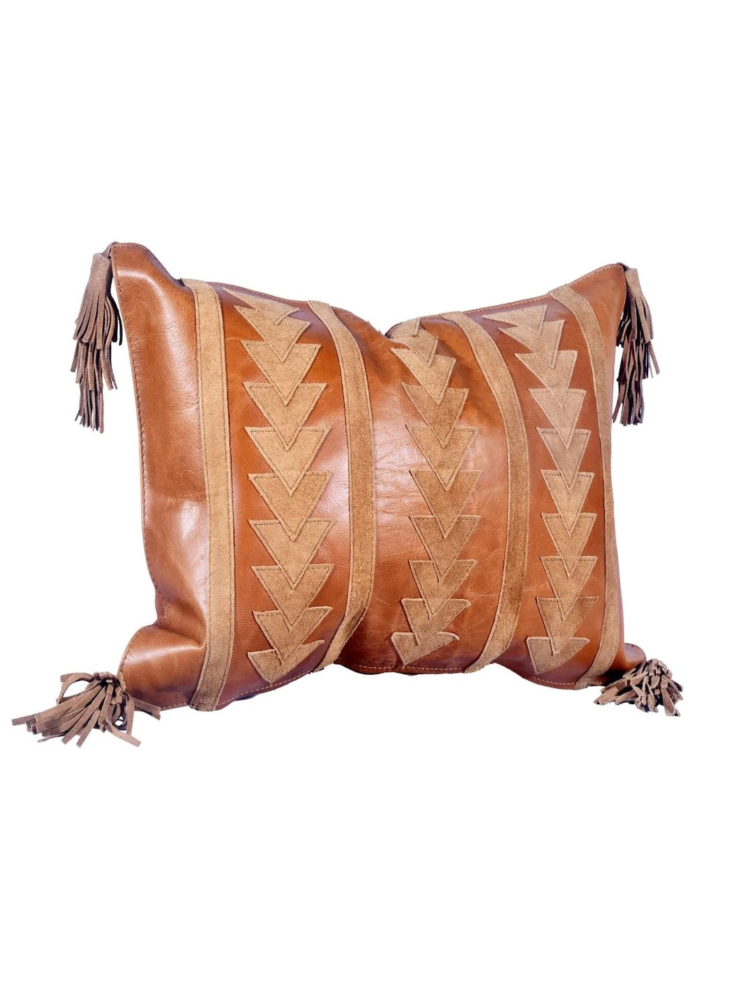 Brown leather pillow with geometric patterns and tassels on a white background