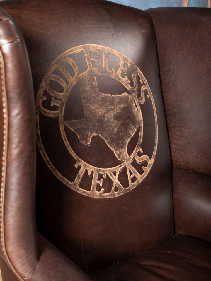 Texas Legacy Leather Wingback Chair in brown leather with "God Bless Texas" etched on inside back in a close up view.