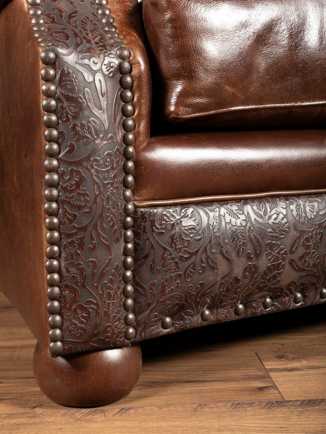 Texas Luxe Leather Curved Sofa with embossed leather detailing on the trim in a close up view.