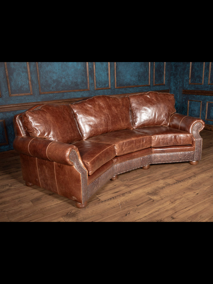 Texas Luxe Leather Curved Sofa featuring a curved silhouette design with and full-grain leather in a rustic space.
