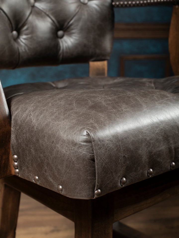 Tufted Greystone Leather Bar Stool with full grain leather seat and silver nailhead trim in a close up view.